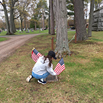 Me planting flags on veterans tombstones.